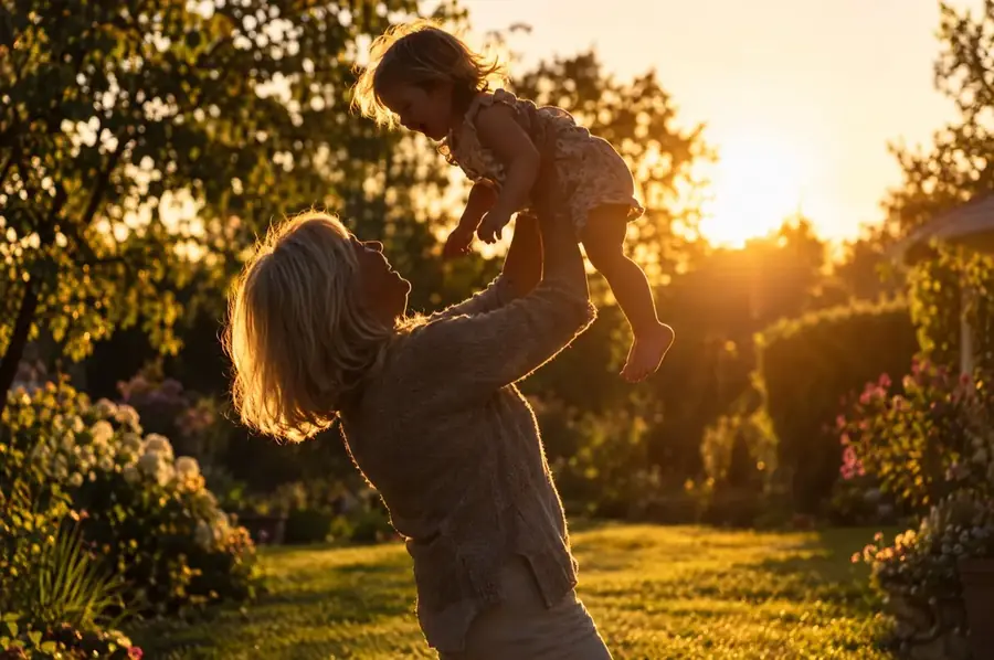 A grandmother lifting a laughing toddler in a sunlit garden